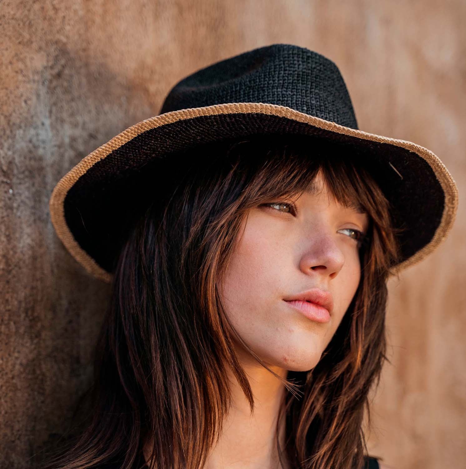 Black straw hat with tan brim made from Toquilla straw, a genuine Panama hat