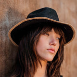 Black straw hat with tan brim made from Toquilla straw, a genuine Panama hat