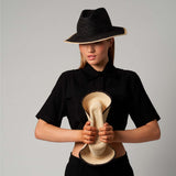 Woman showcasing Paya Packable hats made from Toquilla straw and sustainable materials