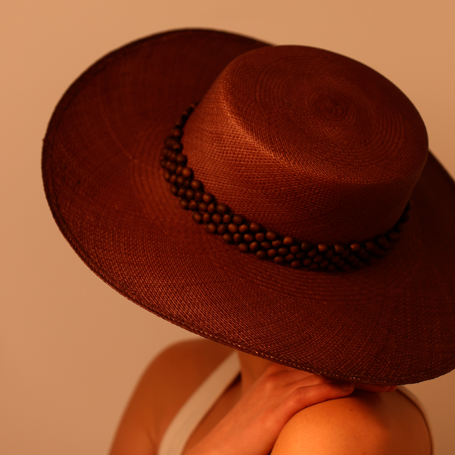 Brown wide-brimmed hat made of natural toquilla straw with beaded tagua nut band