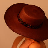 Brown wide-brimmed hat made of natural toquilla straw with beaded tagua nut band