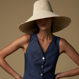 Woman wearing Verona Extra Wide Brim Packable straw hat and navy vest in sunny setting