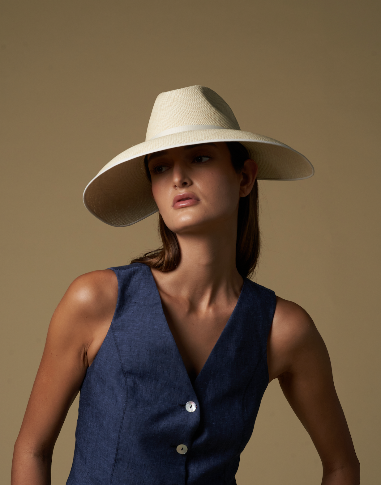 Woman wearing a wide-brim toquilla straw visor hat and navy vest for stylish sun protection