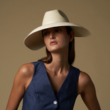 Woman wearing a wide-brim toquilla straw visor hat and navy vest for stylish sun protection