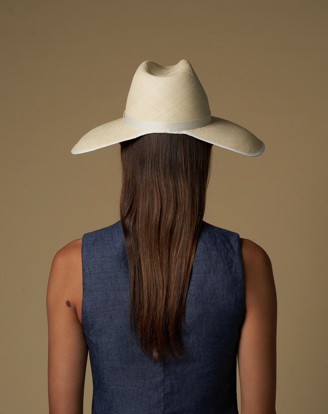 Woman in a straw cowboy hat, showcasing the wide brim Anna Visor Hat in toquilla straw
