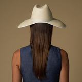 Woman in a straw cowboy hat, showcasing the wide brim Anna Visor Hat in toquilla straw