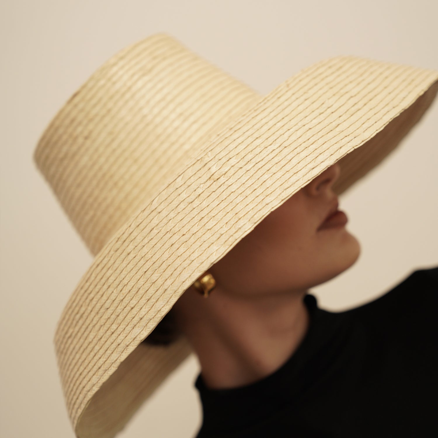 Wide-brimmed straw sun hat made from natural mocora straw, perfect for sunny days