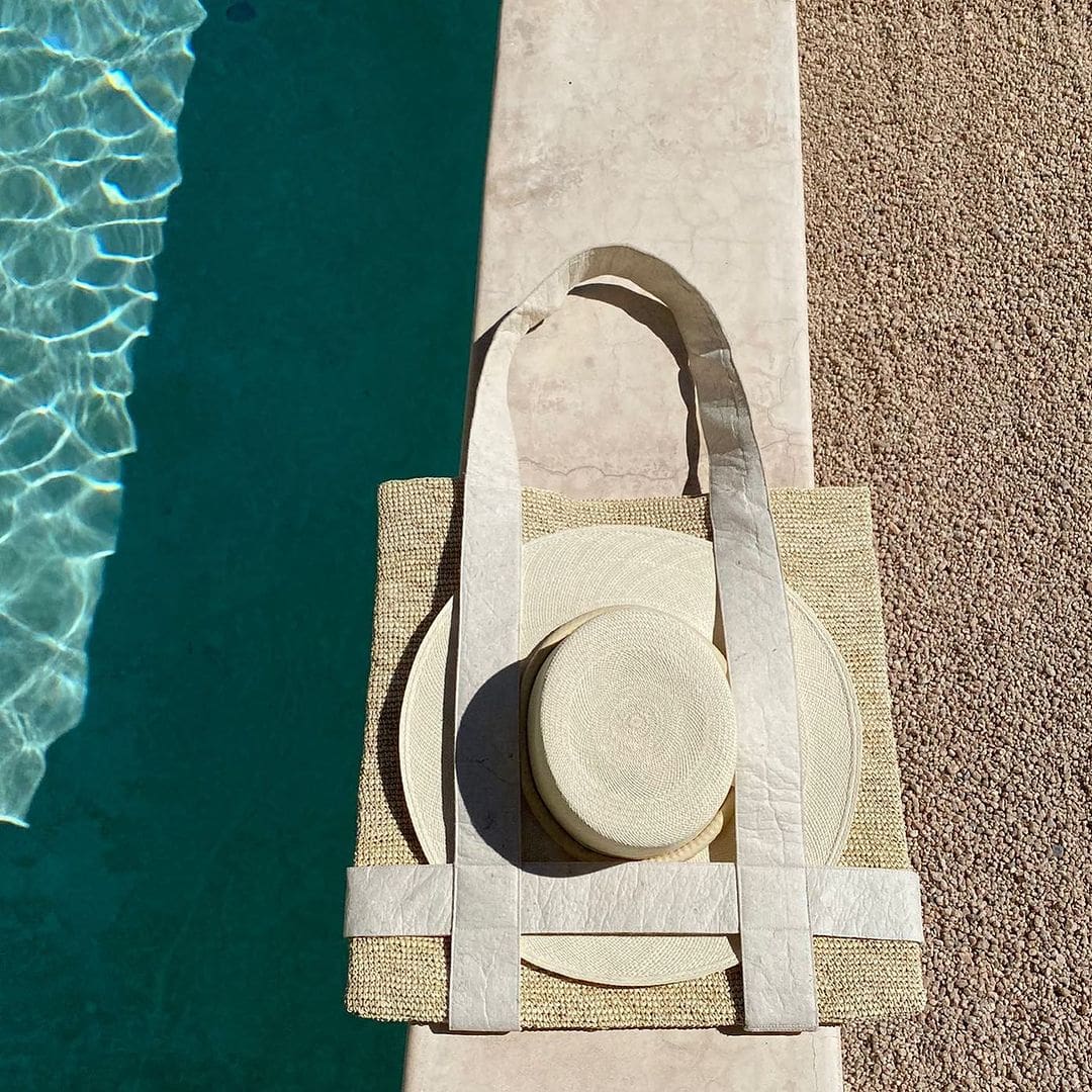 Woven Nativa tote bag with natural toquilla straw, hat, and decorative plates