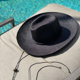 Black straw sun hat from Bromelia featuring natural toquilla straw and chin strap