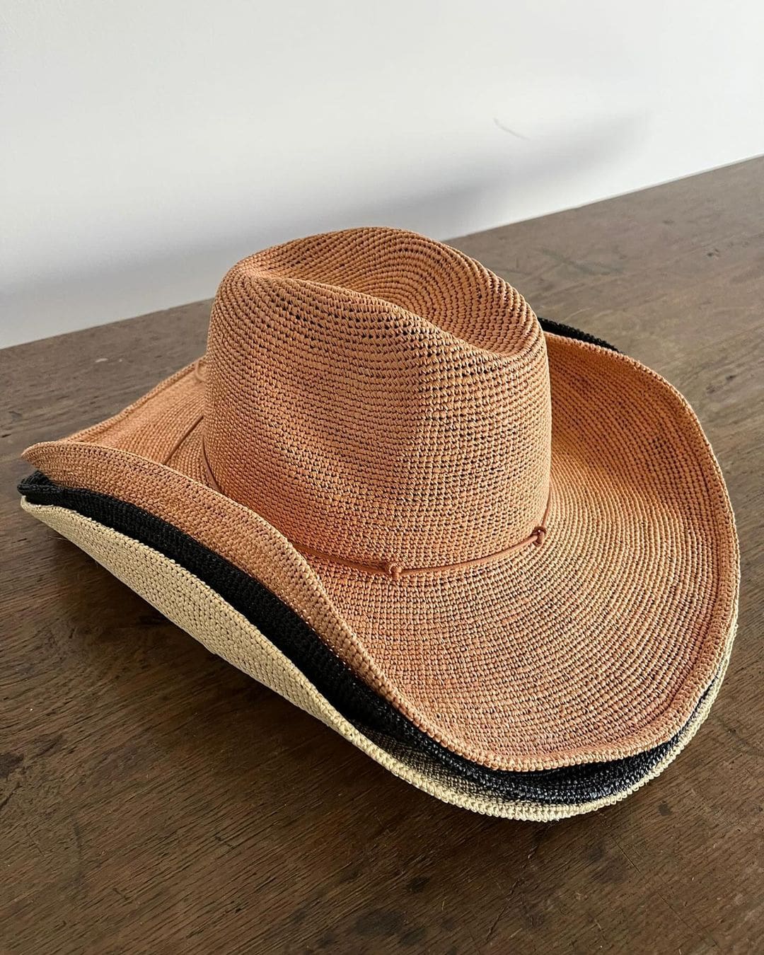 Woven straw cowboy hat with a dark band, ethically handcrafted from Toquilla straw