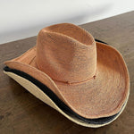 Woven straw cowboy hat with a dark band, ethically handcrafted from Toquilla straw