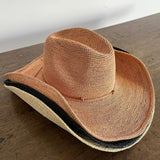Woven straw cowboy hat with a dark band, ethically handcrafted from Toquilla straw