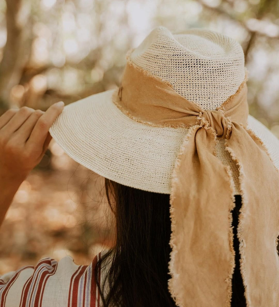 Straw hat with tan ribbon made from toquilla straw, featuring custom initials design