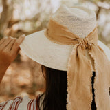 Straw hat with tan ribbon made from toquilla straw, featuring custom initials design