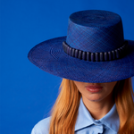Blue toquilla straw wide brim hat with dark band for stylish sun protection