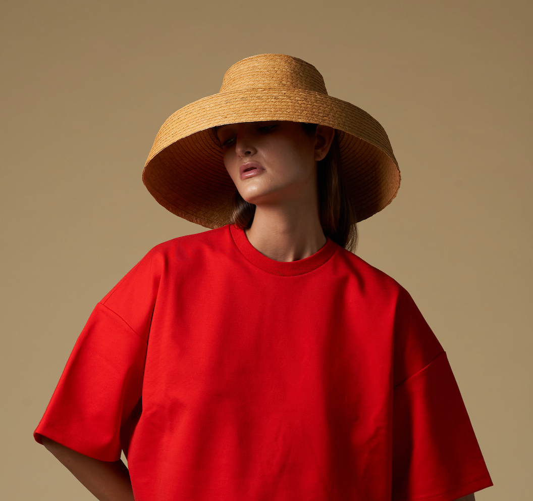 Woman in red shirt and straw hat made of natural mocora straw in Bali