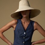 Woman wearing Verona Extra Wide Brim Packable straw hat and navy vest in sunny setting