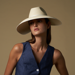 Woman wearing a wide-brim toquilla straw visor hat and navy vest for stylish sun protection