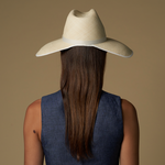 Woman in a straw cowboy hat, showcasing the wide brim Anna Visor Hat in toquilla straw