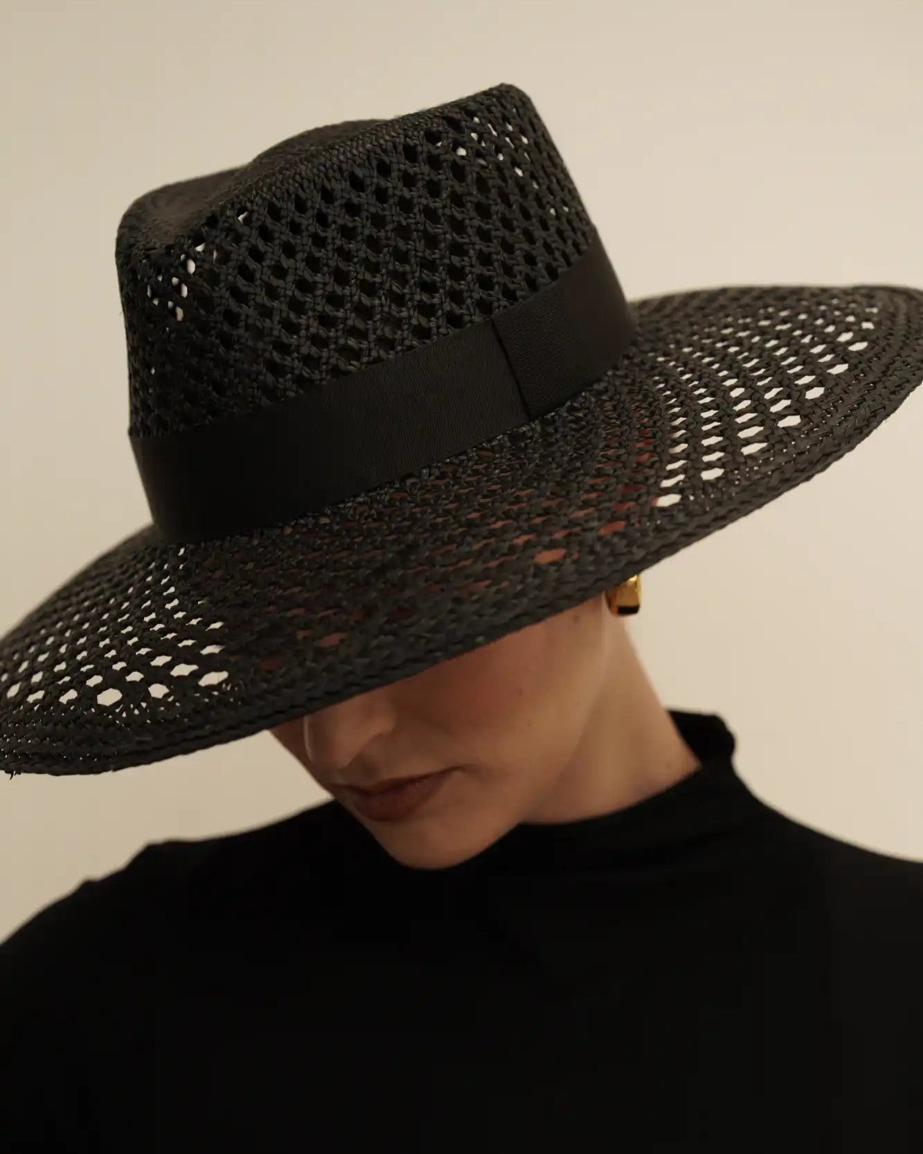 Black woven wide-brim sun hat with an open lattice pattern.