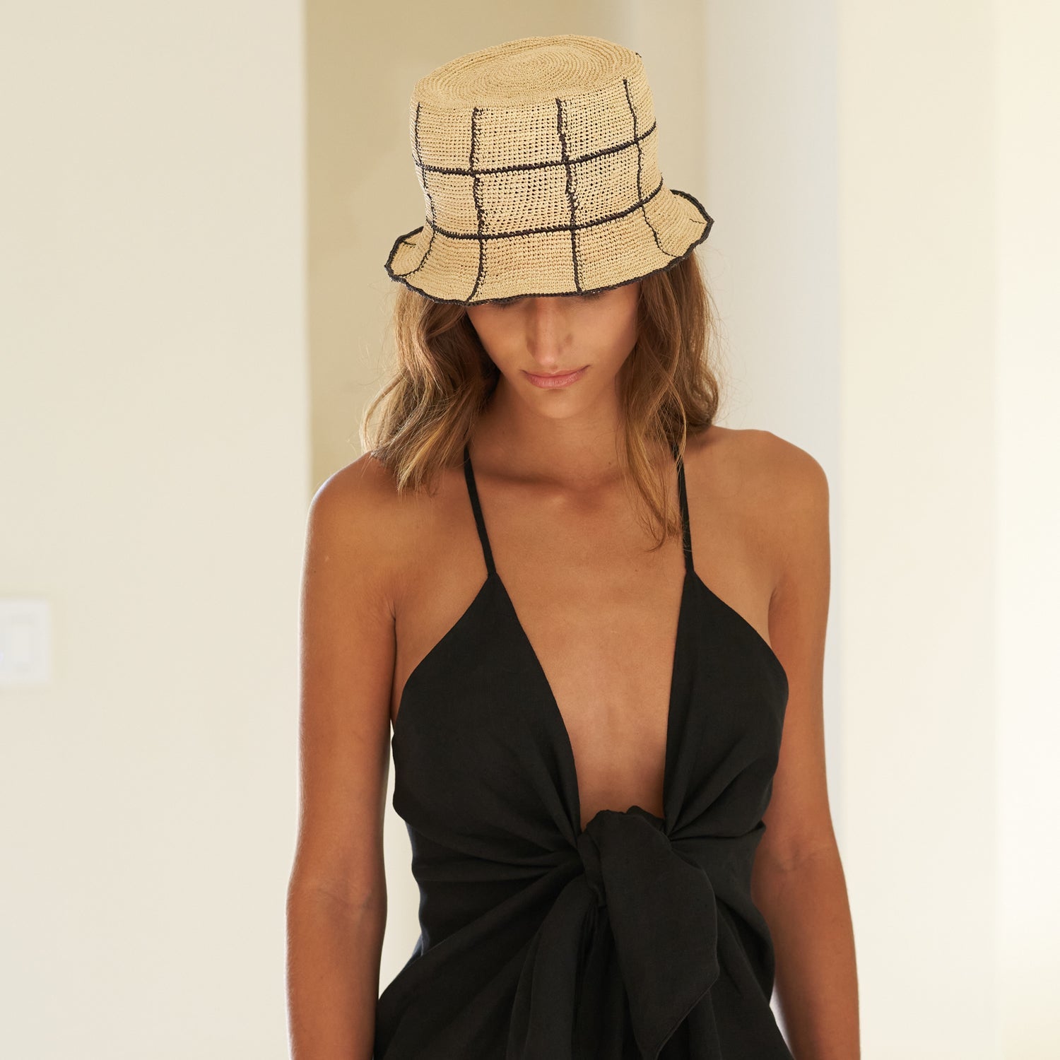 Woman in a black dress wearing a Cruz Packable genuine Panama hat made from toquilla straw